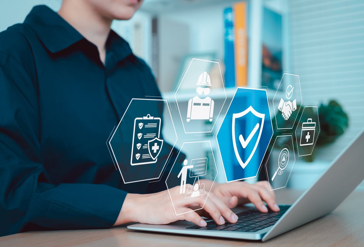 Work safety and compliance concept. A person using a laptop with digital icons representing work safety, compliance, regulations, and professional standards
