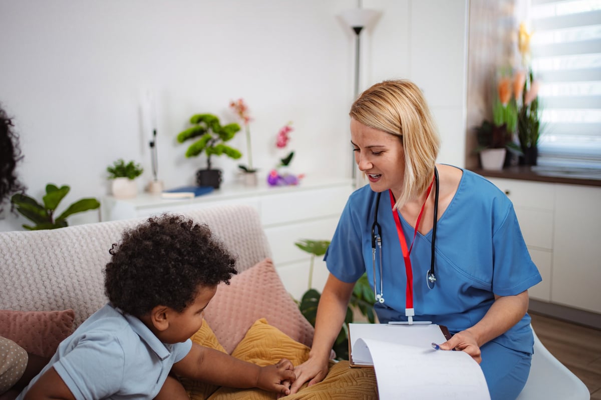 Pediatric nurse checking child's health during home visit