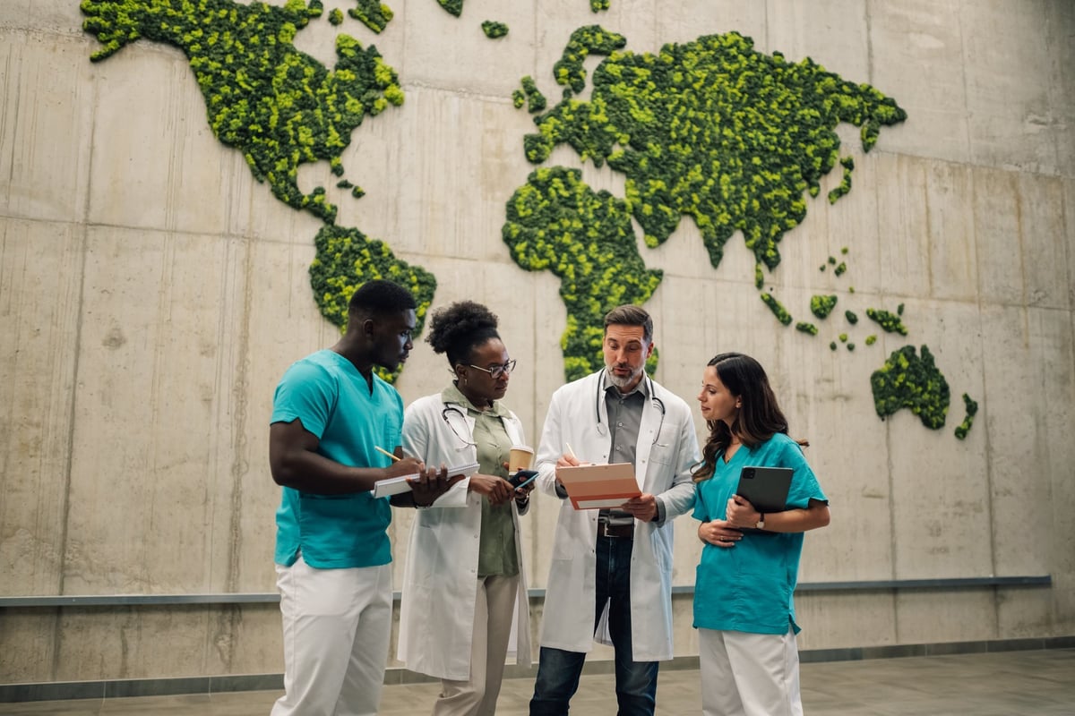Group of diverse medical professionals discussing global healthcare or environmental issues, standing in front of world map